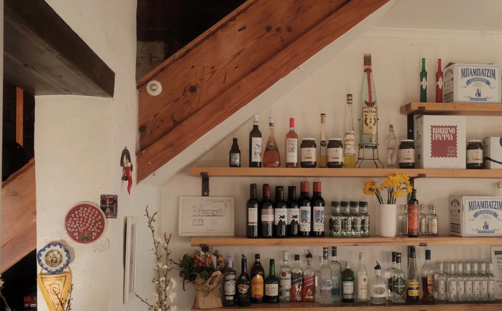 Greek spirits on shelves beside the Alpha Ouzeri staircase